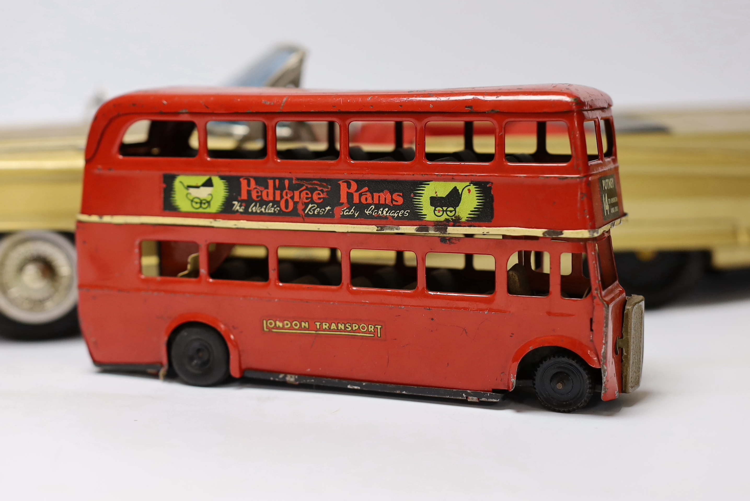 Four tinplate toys; a Frog Interceptor Fighter, a Bandai battery powered Cadillac Convertible (4025), a Crawford’s Biscuits Aeroplane and a clockwork Tri-ang Minic London Transport Double deck bus